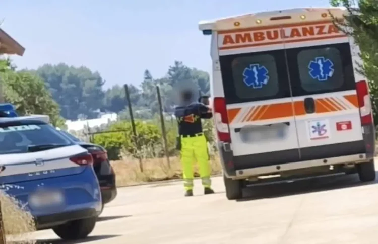 Ambulanza del 118 e auto della Polizia di Stato ferme su una strada, con un soccorritore in divisa ad alta visibilità