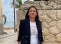 Antonella Salerno, nuova presidente della Pro Loco Mazzarelli, in giacca blu davanti a un muro di pietra vicino al mare