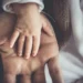 La mano di un neonato appoggiata sul palmo di un adulto, immagine simbolo dell’assegno unico per i figli