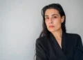 Aurora Miriam Scala, che interpreta Franca Viola al Teatro Donnafugata, in giacca nera davanti a un muro bianco