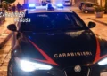 Gazzella dei carabinieri con i lampeggianti blu accesi di notte, ferma su una strada lastricata nella zona di Modica