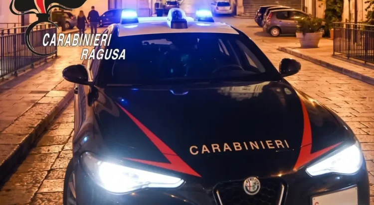 Gazzella dei carabinieri con i lampeggianti blu accesi di notte, ferma su una strada lastricata nella zona di Modica