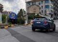 Treno regionale vicino al passaggio a livello di via Paestum a Ragusa mentre un'auto attraversa i binari
