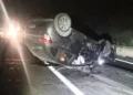 Auto grigia capovolta sulla Ss 115 vicino a Vittoria, di notte, tra detriti sull’asfalto e fari di veicoli fermi