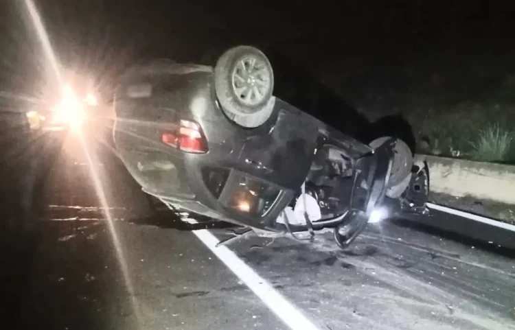 Auto grigia capovolta sulla Ss 115 vicino a Vittoria, di notte, tra detriti sull’asfalto e fari di veicoli fermi