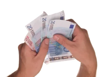 Due mani tengono a ventaglio banconote da 20 e 10 euro su sfondo bianco, immagine simbolo dei fringe benefit