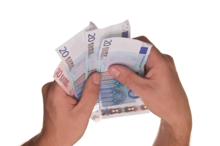 Due mani tengono a ventaglio banconote da 20 e 10 euro su sfondo bianco, immagine simbolo dei fringe benefit