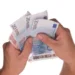 Due mani tengono a ventaglio banconote da 20 e 10 euro su sfondo bianco, immagine simbolo dei fringe benefit