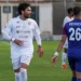 Calciatore del Modica in maglia bianca numero 29 in campo durante una partita, accanto a un avversario in maglia blu e rossa