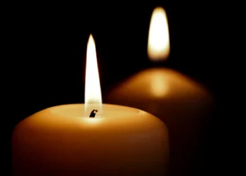 Due candele accese su sfondo nero, immagine di cordoglio per il carabiniere morto a Trapani