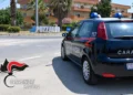 Auto dei Carabinieri con il numero 112 sulla fiancata, ferma accanto alla grande scritta Pozzallo all’ingresso della città