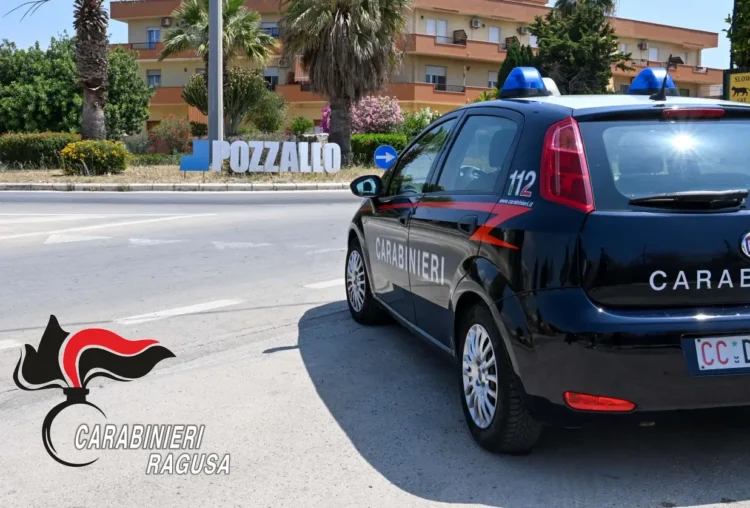 Auto dei Carabinieri con il numero 112 sulla fiancata, ferma accanto alla grande scritta Pozzallo all’ingresso della città