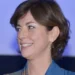 Carlotta Schininà, socia di Anele e sostenitrice del film su Biagio Conte, sorride di profilo con camicia blu e orecchini dorati