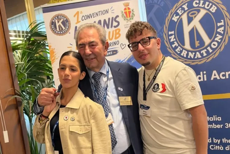 Tre partecipanti posano davanti ai banner del Key Club International alla prima convention del distretto H45 a Messina