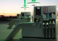 Colonnine di un distributore di carburanti al tramonto, con pistole diesel e benzina e i prezzi al litro esposti
