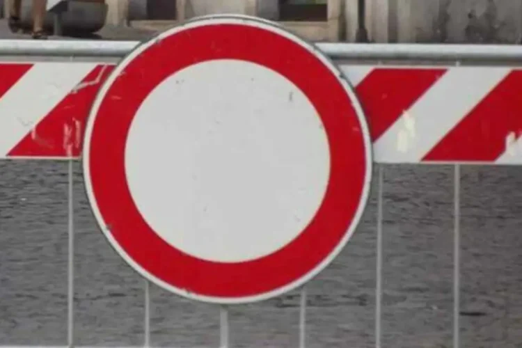 Cartello di divieto di transito su una transenna a strisce bianche e rosse per la chiusura di una strada