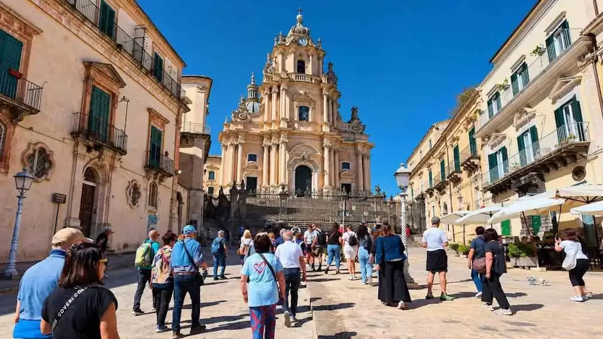 Turisti in piazza Duomo a Ragusa Ibla verso il Duomo di San Giorgio, chiesa barocca del sito Unesco