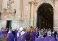 Sacerdoti in paramenti viola portano la bara di don Salvatore Dinatale fuori dalla cattedrale di Ragusa, tra i fedeli
