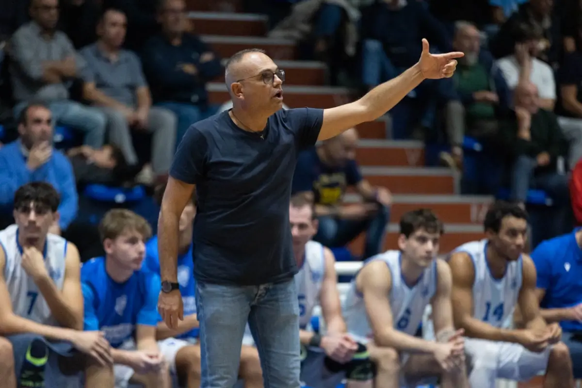 Il coach della Virtus Ragusa Gianni Recupido dà indicazioni a bordo campo, alle spalle i giocatori seduti in panchina