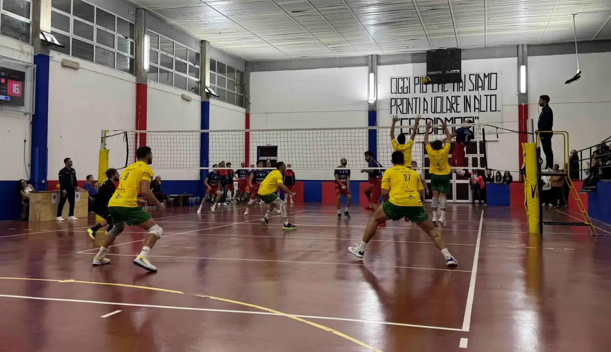 Attacco a rete in Giarratana Volley-Gibellina: giocatori in gialloverde al muro contro uno schiacciatore in maglia rossoblù