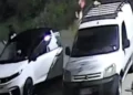 Fermo immagine notturno a Vittoria: due giovani accanto a un’auto bianca e a un furgone con portapacchi sul tetto