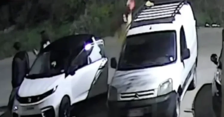 Fermo immagine notturno a Vittoria: due giovani accanto a un’auto bianca e a un furgone con portapacchi sul tetto