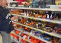 Finanziere controlla articoli di Halloween su uno scaffale: zucche arancioni, maschere e decorazioni in un negozio a Ragusa