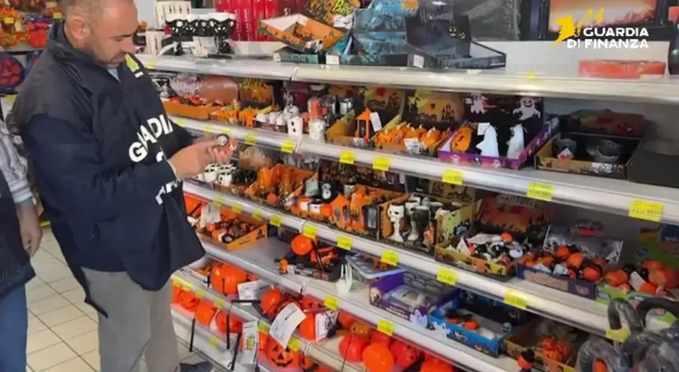 Finanziere controlla articoli di Halloween su uno scaffale: zucche arancioni, maschere e decorazioni in un negozio a Ragusa