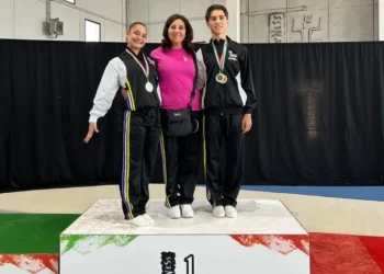 Due atleti di ginnastica aerobica della Motyka Modica con le medaglie sul gradino più alto del podio, accanto all’istruttrice