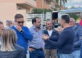 Rappresentanti politici e ambulanti a confronto in strada al mercato del venerdì di Comiso, accanto a un furgone e a una bancarella
