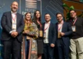Premiazione IngegnoLab agli Hotel Designer Awards: sei persone sul palco, una donna regge il trofeo Smart & Tech Room