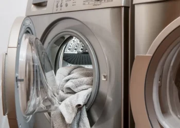 Lavatrice a carica frontale con oblò aperto e asciugamano grigio, grande elettrodomestico ammesso al bonus mobili 2026