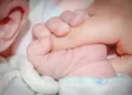 Genitore tiene in braccio un neonato
