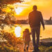 Padre e figlio piccolo di spalle camminano verso un lago al tramonto, immagine sull’assegno unico per le famiglie