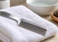 Pettine a denti fitti su un asciugamano, usato per eliminare i pidocchi. Immagine generata con intelligenza artificiale