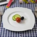 Piatto con due fette di cetriolo, un pomodorino e un’oliva, tra metri da sarta e bilancia: una cena ridotta per dimagrire