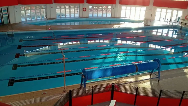 Vasca coperta della piscina comunale di Modica con le corsie divise da galleggianti rossi e blu, vista dall’alto