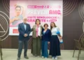 Un uomo e tre donne davanti allo striscione rosa delle visite senologiche gratuite di Ragusa in Rosa all’Interspar Le Dune