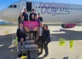 Equipaggio Wizz Air e rappresentanti sulla scaletta dell’aereo con il cartello del primo volo Comiso-Milano Malpensa