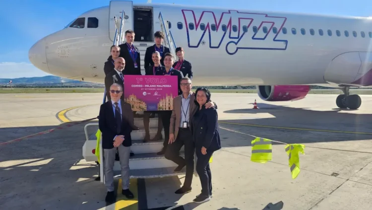 Equipaggio Wizz Air e rappresentanti sulla scaletta dell’aereo con il cartello del primo volo Comiso-Milano Malpensa