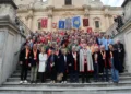 Foto di gruppo del raduno Fice: confratelli in mantelli e medaglie sulla scalinata di una chiesa barocca, con gli stendardi
