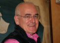 Salvatore Saccone sorridente, con occhiali senza montatura, camicia rosa e gilet nero