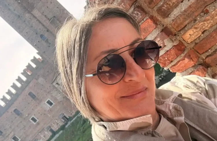 Rosa Anna Paolino, consigliera Anc, con occhiali da sole rotondi davanti a un muro di mattoni e a una torre merlata