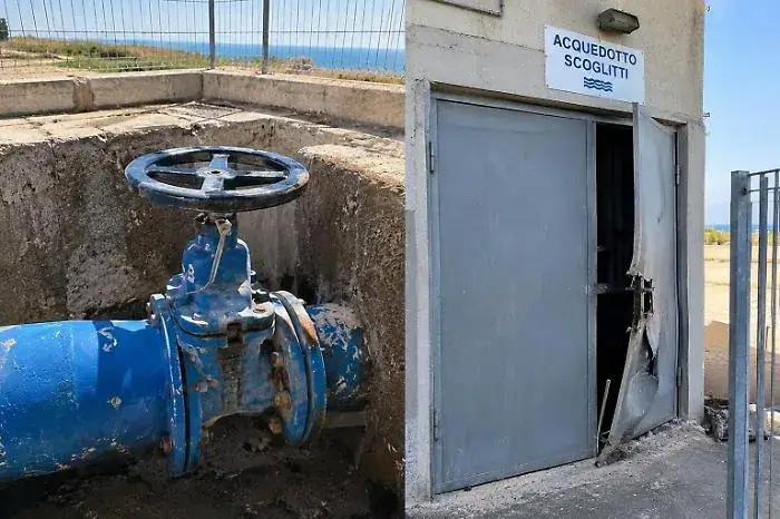Saracinesca blu in un pozzetto dell’acquedotto di Scoglitti e porta metallica dell’impianto piegata e aperta