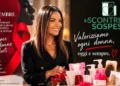 Locandina dello Scontrino Sospeso di Modica per il 25 novembre: una donna sorride accanto a prodotti per l’igiene e cosmetici