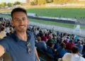 Simone Digrandi in un selfie in tribuna durante una partita di calcio, con il pubblico sugli spalti alle sue spalle