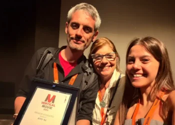 Simone Lucifora regge la targa Miglior soggetto del VerticalMovie 2026 per Atto '84, accanto a due donne sorridenti