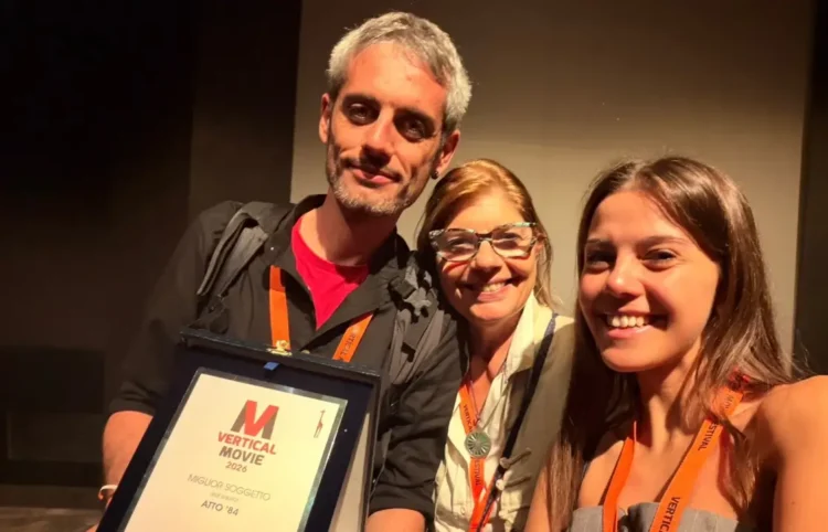 Simone Lucifora regge la targa Miglior soggetto del VerticalMovie 2026 per Atto '84, accanto a due donne sorridenti