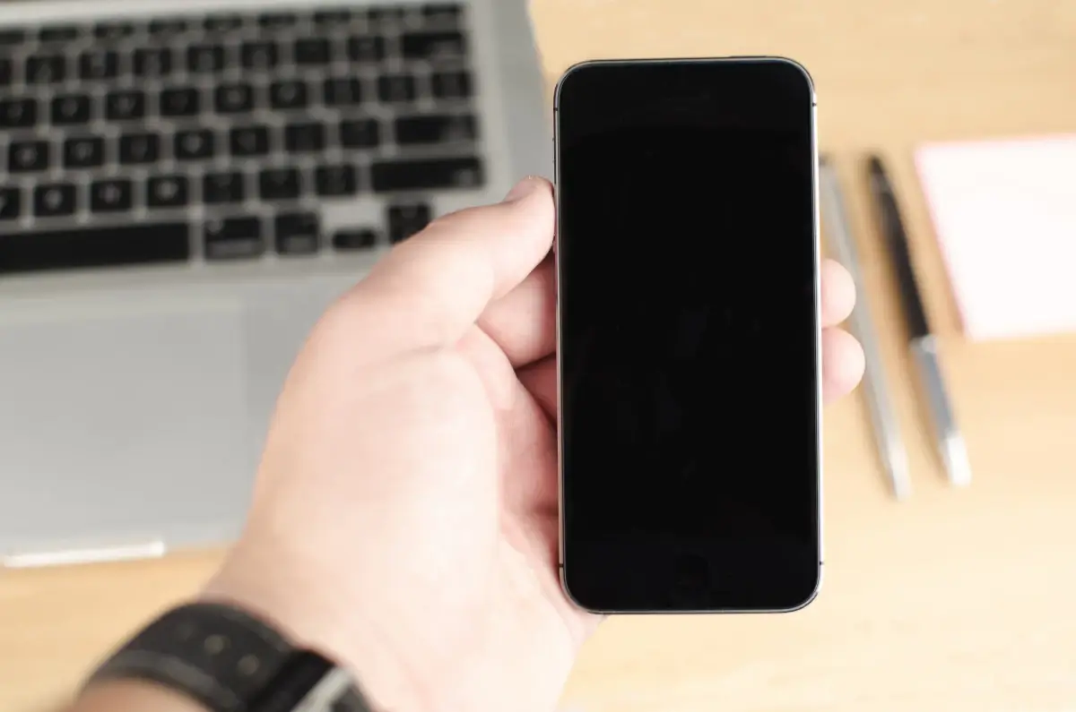 Mano che tiene uno smartphone con la schermata di blocco, come dopo un furto