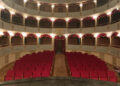 Platea del Teatro Garibaldi di Modica con poltrone rosse, palchi su tre ordini e tendaggi bordeaux